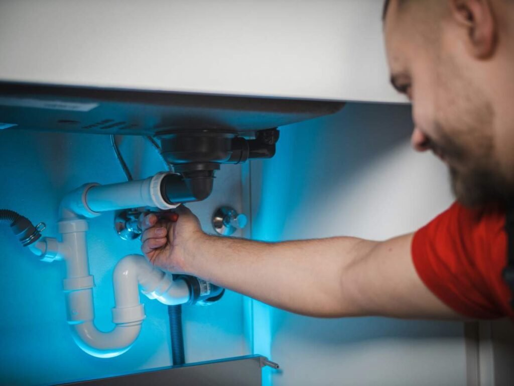 plumber working under sink